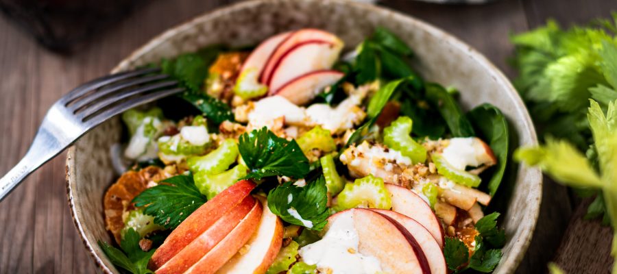 Traditional Waldorf salad of apples, celery and walnuts on a rustic table